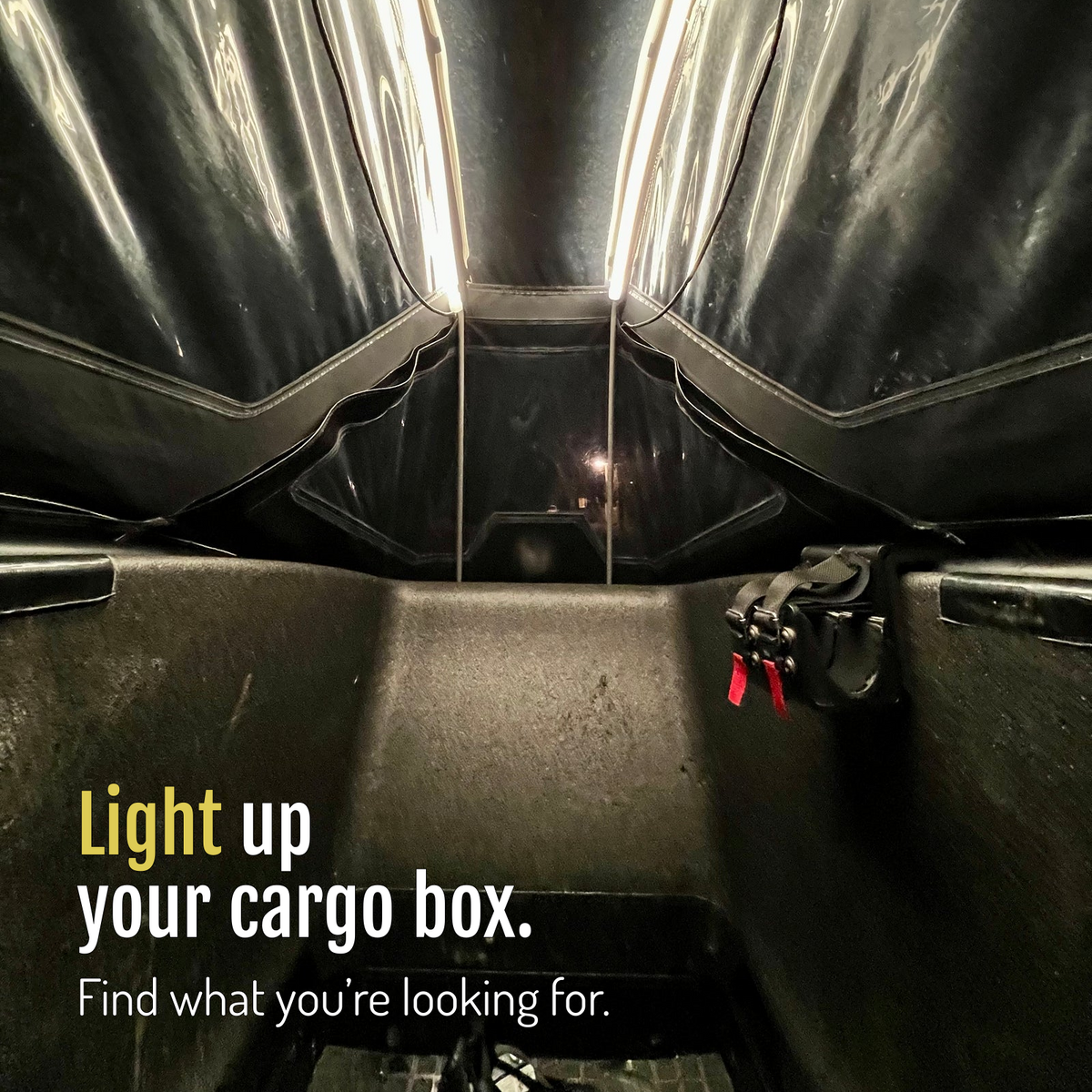 [en] Two CargoGLOW light strips illuminate the cargo bike box beneath its canopy, showing the seat and straps. Light up your cargo box and find what you're looking for.