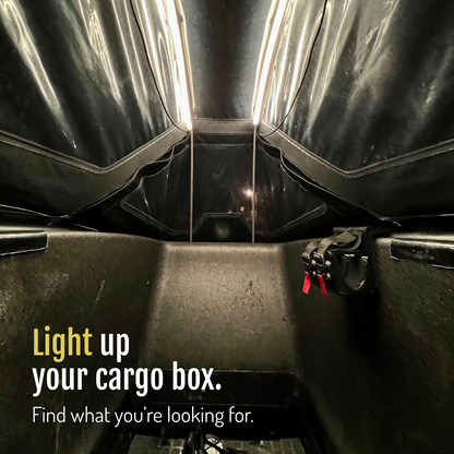 [en] Two CargoGLOW light strips illuminate the cargo bike box beneath its canopy, showing the seat and straps. Light up your cargo box and find what you're looking for.