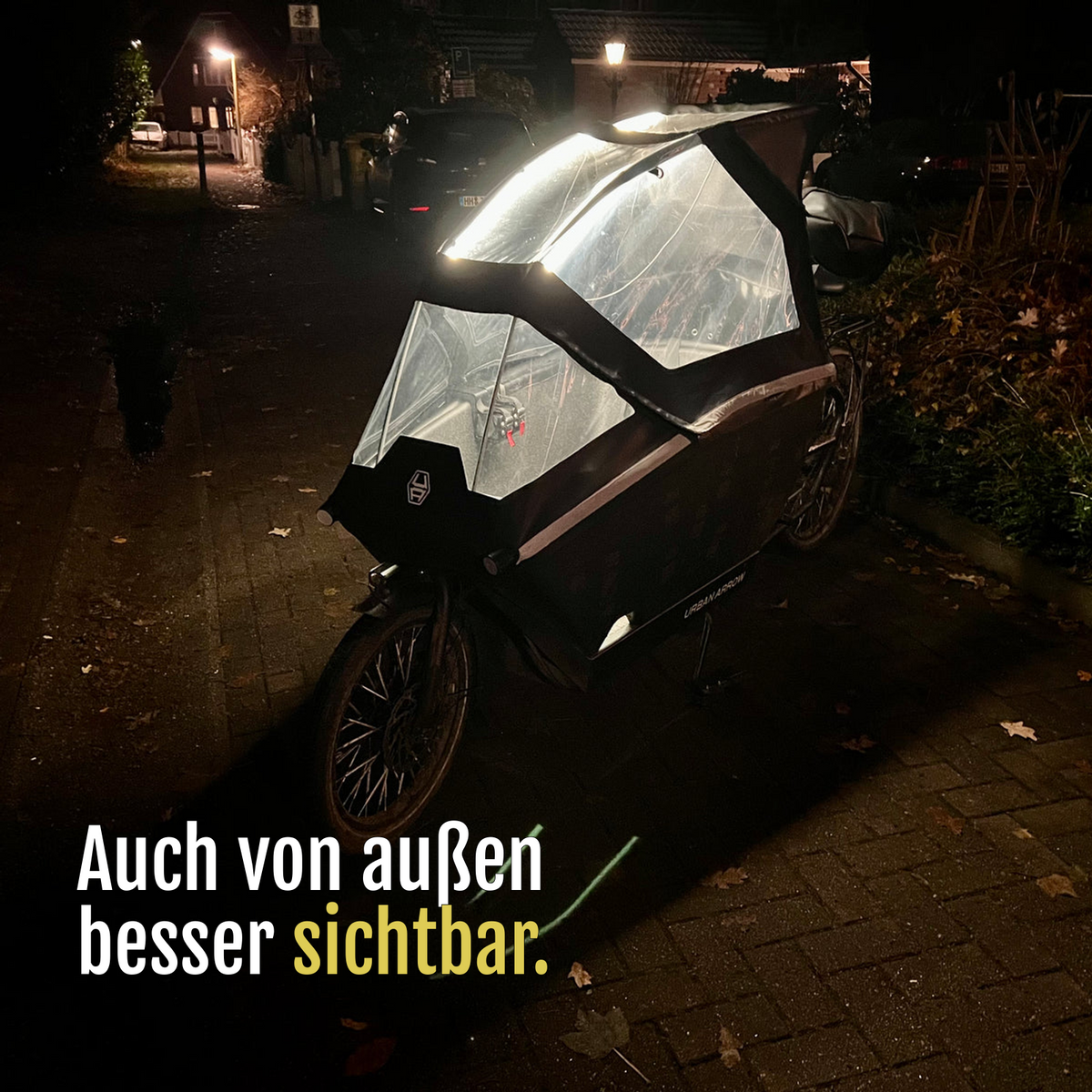 [de] Lastenrad mit von CargoGLOW beleuchtetem Regenverdeck, bei Dunkelheit von außen aufgenommen. Auch von außen besser sichtbar.