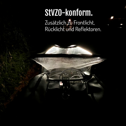 [de] Blick über den Lenker auf das von CargoGLOW beleuchtete Regenverdeck bei Dunkelheit. StVZO-konform, zusätzlich zu Frontlicht, Rücklicht und Reflektoren.