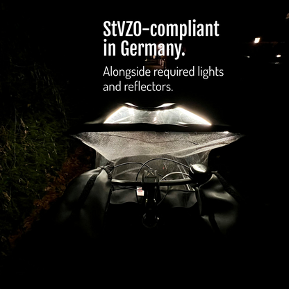 [en] View over the handlebar towards the canopy illuminated by CargoGLOW at night. StVZO-compliant in Germany, alongside required lights and reflectors.